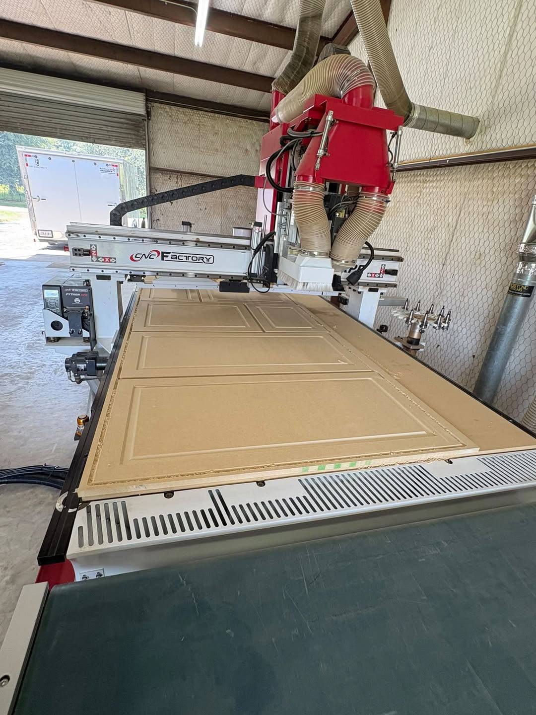 CNC router in the Tim Brown Builders shop cutting a raised-panel cabinet door blank